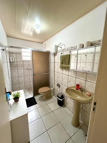 a small bathroom with a toilet and a sink at Casa Buarque de Macêdo 494 in Rio Grande