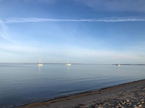 three boats floating in the water near a beach at 8 person holiday home in Bagenkop-By Traum in Bagenkop