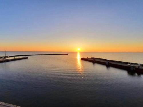 a sunset over a body of water with a pier at 8 person holiday home in Bagenkop-By Traum in Bagenkop