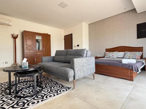 a living room with a couch and a bed at Studio Ngor, route de l'aéroport in Ngor