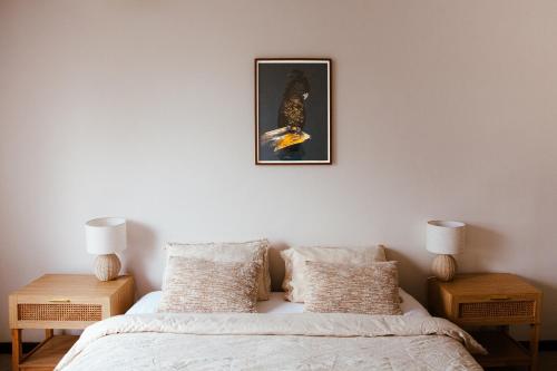 a bedroom with a bed with two night stands and a picture on the wall at Nest at Maggies in Melbourne