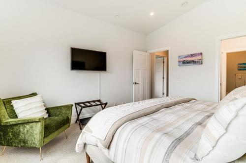 a bedroom with a large bed and a green chair at Half Moon Bay Vacation Rental 1 Mile to Beach! in Half Moon Bay