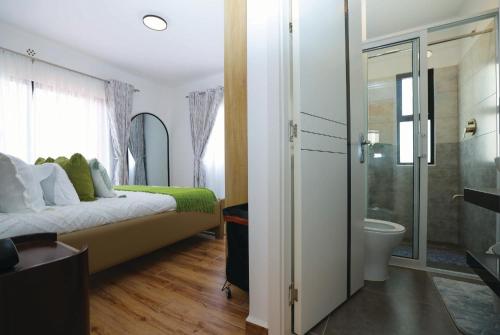 a bedroom with a bed and a bathroom with a shower at Premium Luxury 2-Bedroom Apartment in Tatu City