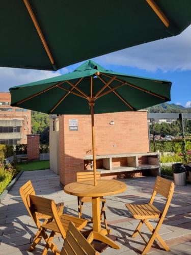 a table and chairs with an umbrella on a patio at Aparta estudio en la candelaria WiFi rápido-a pasos del museo de oro in Bogotá