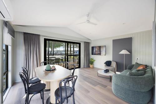 a living room with a couch and a table at Reflections Forster Beach - Holiday Park in Forster