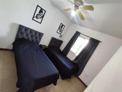 a bedroom with a black bed and a ceiling fan at Rincón de Lujan in Ciudad Lujan de Cuyo