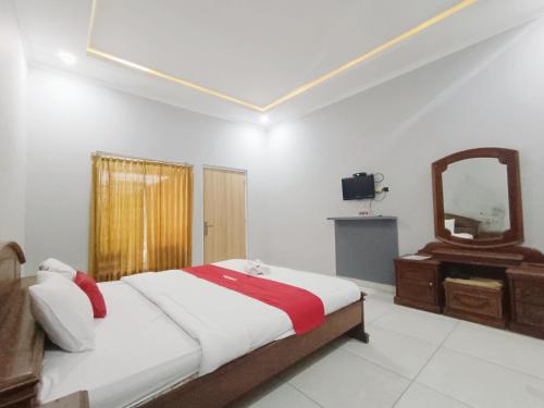 a bedroom with a large bed and a mirror at Hotel Istana Syariah Pekalongan by Hello Room in Pekalongan