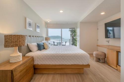 a bedroom with a large bed and a television at Stunning Beachfront 1BR Suite with Ocean View in Jacó