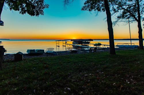 un tramonto su un lago con tavoli e barche in acqua di Dog Friendly Leech Lake Home w Perfect Beach Garage Boat Lift a Walker