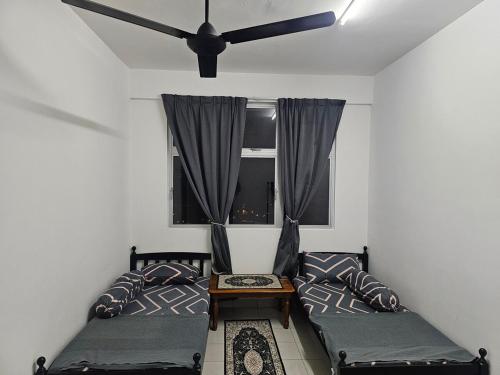 a living room with two beds and a ceiling fan at Homestay Saderi Putrajaya Presint 16 in Putrajaya