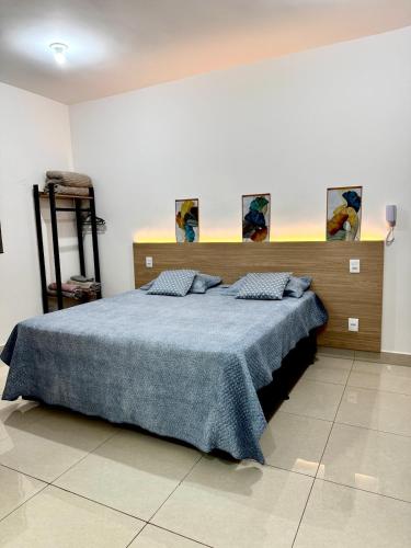 a bedroom with a large bed with a blue blanket at Blue Life Torre 1 in Anápolis