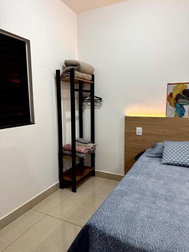 a bedroom with a bed and a shelf with towels at Blue Life Torre 1 in Anápolis