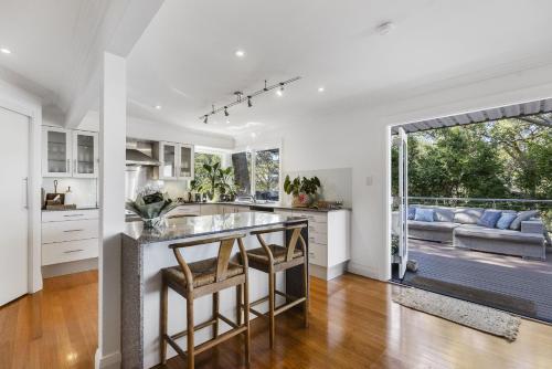 a kitchen with white cabinets and a large window at Paraiso Del Mar - by Coast Hosting in Copacabana
