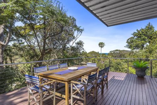 an outdoor deck with a wooden table and chairs at Paraiso Del Mar - by Coast Hosting in Copacabana