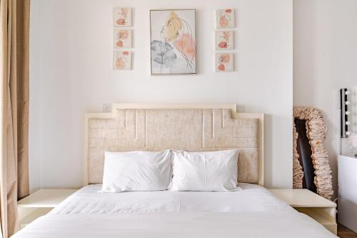 a bedroom with a white bed with two pictures on the wall at Stunning lake view 1bedroom apartment in Jlt in Dubai