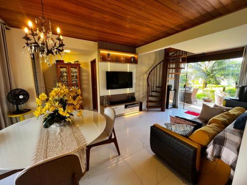 a living room with a dining table and a couch at Bangalô aconchegante e luxuoso Winterville Resort Gravatá PE in Gravatá