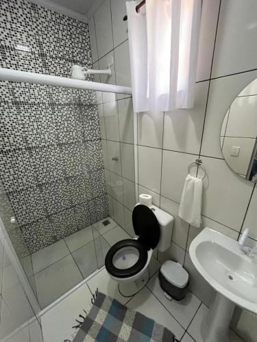 a small bathroom with a toilet and a sink at Pousada Gaivotas in Trindade
