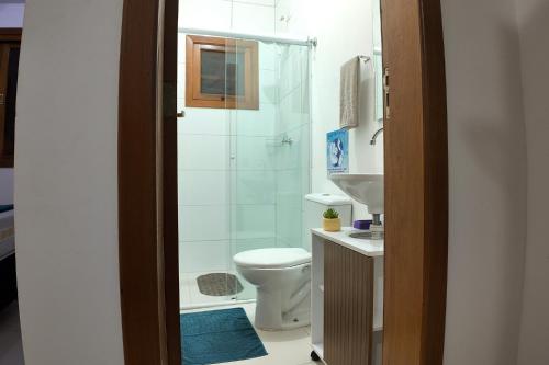 a bathroom with a toilet and a shower at Balangan Flats in Ubatuba