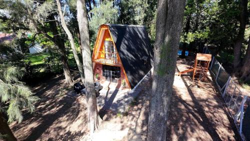 a tree house in the middle of some trees at Hermosa Cabaña Alpina Zona Oeste in General Rodríguez