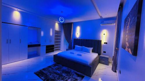 een slaapkamer met een bed in een blauwe kamer bij D-Lezzubra Luxury Apartments in Gwarinpa