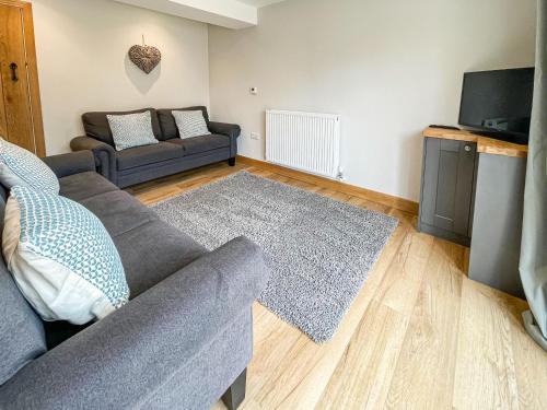 a living room with a couch and a tv at The Willows - Uk34000 in Child Okeford