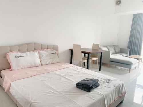 a bedroom with a bed and a chair and a table at The Sun Avenue Serviced Apartment in Ho Chi Minh City