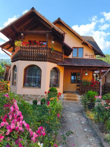 a house with flowers in front of it at Casa Georgeta in Câmpulung Moldovenesc
