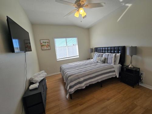 Un dormitorio con una cama y un ventilador de techo. en Sunset Palm Stay, en San Petersburgo