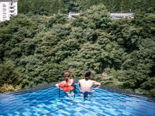 two girls are standing in a swimming pool at Kinugawa Hotel Mikazuki in Nikko