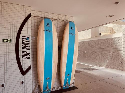 three surfboards are hanging on a wall at Edifício SKY Acomodações in Maceió