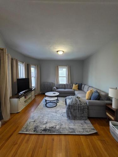 a living room with a couch and a table at The Maverick Upstairs - NEW! - Lux Apartment - 2 Miles From Airport & Downtown Boston in Chelsea