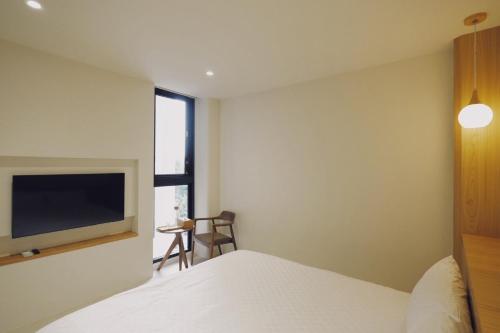 a bedroom with a bed and a flat screen tv at 味知文旅 in Xiaoliuqiu