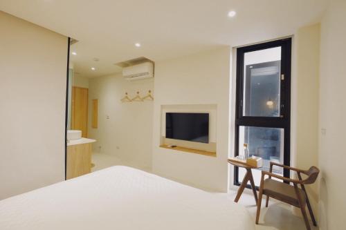 a bedroom with a bed and a chair and a window at 味知文旅 in Xiaoliuqiu
