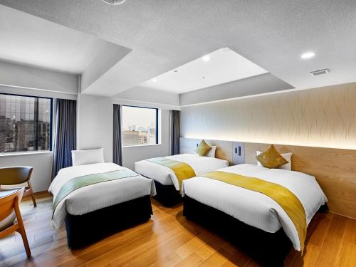 a hotel room with two beds and a window at DEL style Osaka-Shinsaibashi by Daiwa Roynet Hotel in Osaka