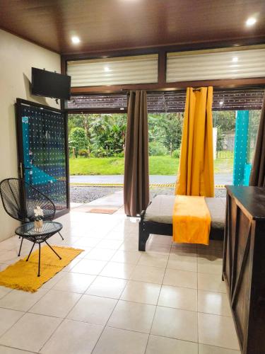 a bedroom with a bed and a large window at Oropendola Lodge in Bajos del Toro