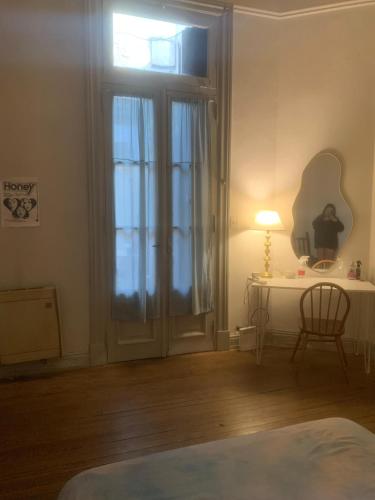 a bedroom with a door and a table with a lamp at Amplia y bonita habitacion en ph compartido en Recoleta in Buenos Aires