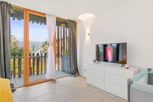 a living room with a television and a balcony at Bodensee Penthouse 23D - Seesicht - Billiard - Massage - Trambolin - BBQ - Tischkicker - Panorama Exklusive in Öhningen