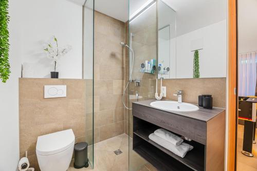 a bathroom with a toilet and a sink at Bodensee Penthouse 23D - Seesicht - Billiard - Massage - Trambolin - BBQ - Tischkicker - Panorama Exklusive in Öhningen