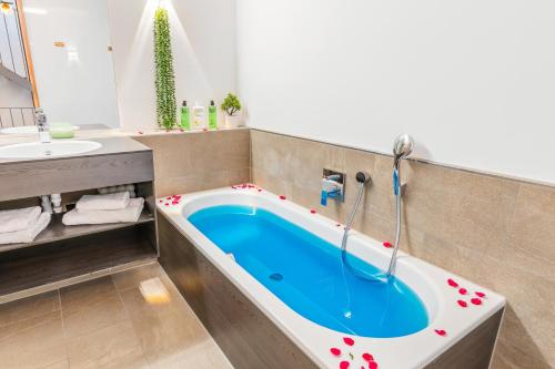 a bathroom with a bath tub with a sink at Bodensee Penthouse 23D - Seesicht - Billiard - Massage - Trambolin - BBQ - Tischkicker - Panorama Exklusive in Öhningen