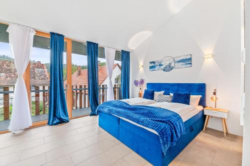 a blue bed in a room with a window at Bodensee Penthouse 23D - Seesicht - Billiard - Massage - Trambolin - BBQ - Tischkicker - Panorama Exklusive in Öhningen