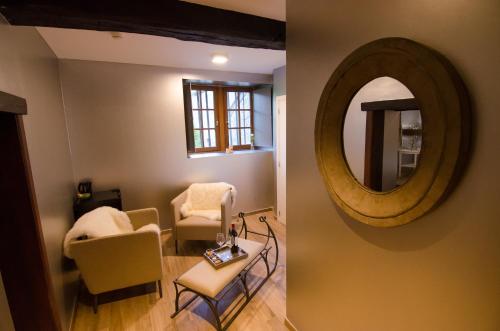 a living room with a mirror and a chair at River Lodge Hotel Insolite in Maredsous