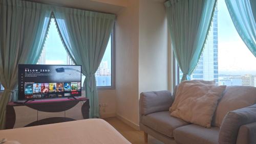a living room with a couch and a flat screen tv at 8 Adriatico Manila Condotel Sea View Corner Unit Near St Lukes Clinic in Manila