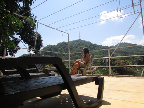 a woman sitting in a chair on a patio with a view at Jumanji in Palomino