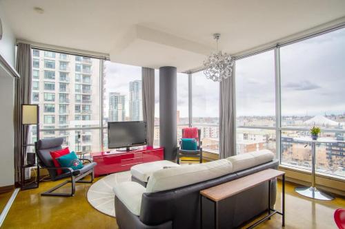 ein Wohnzimmer mit Couch und Fernseher in der Unterkunft Modern Beltline Escape Sky-High Views DT Views in Calgary