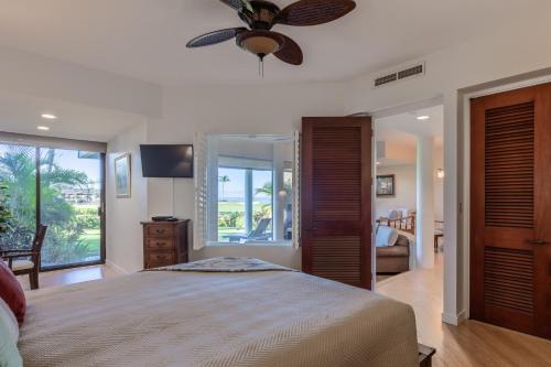 a bedroom with a bed and a ceiling fan at Mauna Lani Point stunning sunset and ocean views in Waikoloa