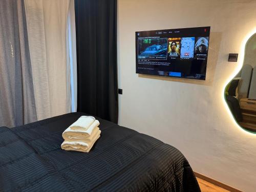 a bedroom with two towels on a bed with a tv on the wall at Studio Le Cœur Casablanca in Casablanca