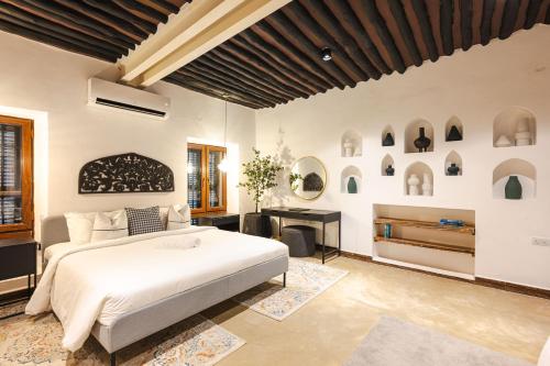 Un dormitorio con una cama blanca grande y un escritorio en Bait Al Bagh Zanzibar Stone Town by Liv Zanzibar, en Ngambo