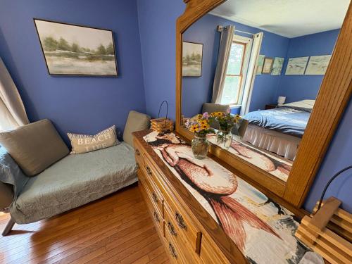 a bedroom with a mirror and a bed and a couch at The Purple Room with private bath in Narragansett