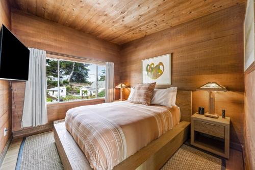 a bedroom with a large bed and a window at Spectacular Bolinas Oceanfront Retreat in Bolinas