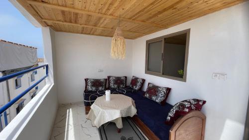 a room with a couch and a table on a balcony at Adar guest house in Agadir